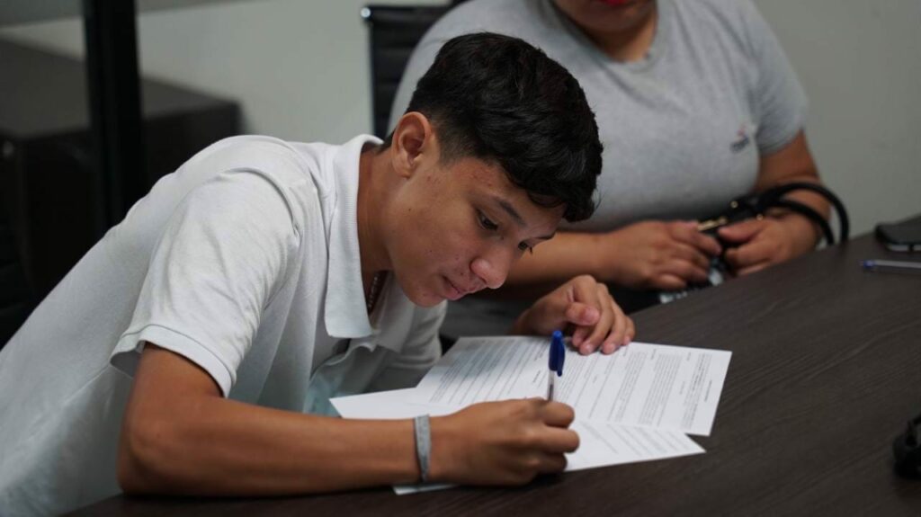 Emocionado, uno de los pequeños futbolistas firma su primer contrato para Tercera División Profesional